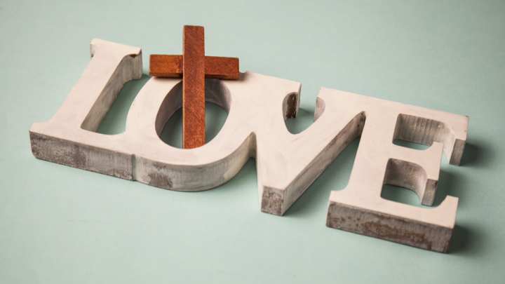 Wooden painted white L O V E with small wooden cross